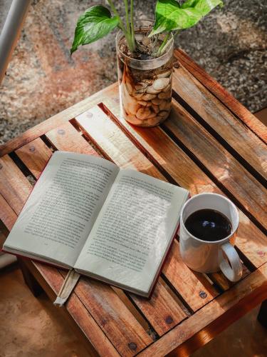 an open book on a wooden table with a cup of coffee at Ku kuk Glamping in Chemuyil