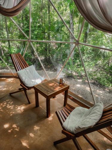 a room with two chairs and a table and a window at Ku kuk Glamping in Chemuyil