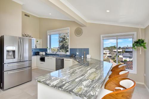 a kitchen with a counter top and a refrigerator at The Sea Serenade in Blacksmiths