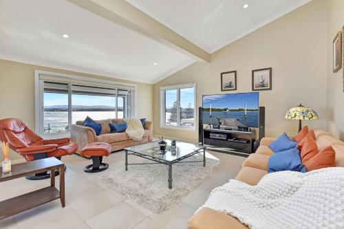 a living room with a couch and a tv at The Sea Serenade in Blacksmiths