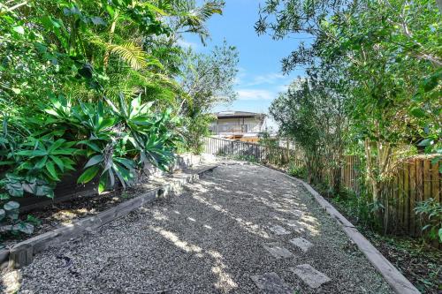 a gravel driveway with trees and a fence at The Sea Serenade in Blacksmiths