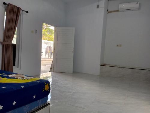 a white room with a bed and a door at Touchsmart in Lemahabang