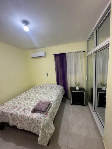 a small bedroom with a bed and a window at house on the hill in Nagua