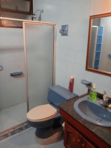 a bathroom with a blue toilet and a sink at Tranquila y cerca de la magia in Cartagena de Indias