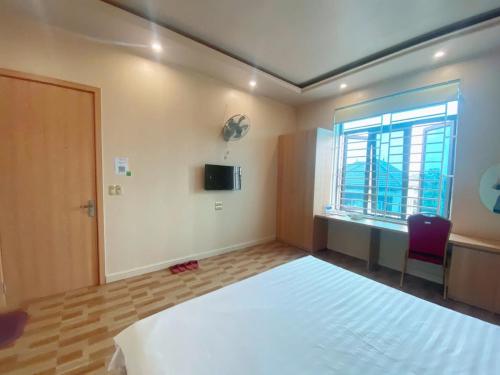 a bedroom with a large bed and a window at thieuki 1 in Hà Tĩnh