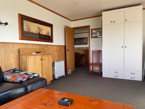 a living room with a couch and a table at 49 on Jans Beach Break in Oakura