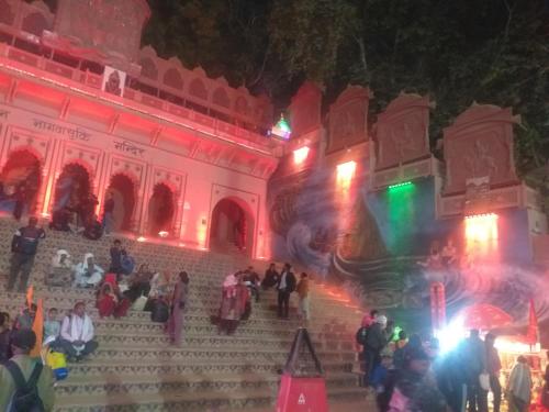 a group of people sitting on the stairs of a building at night at Indra Family Homestay - Nearest Area to Triveni Sangam in Prayagraj