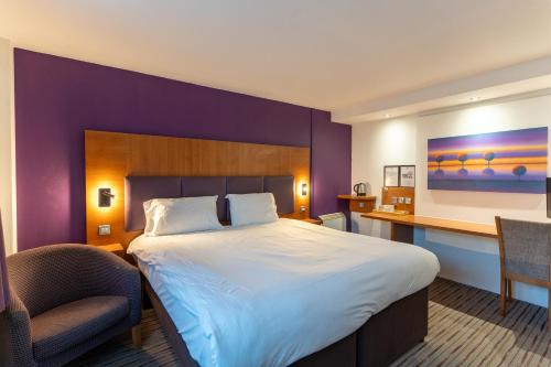 a hotel room with a large bed and a desk at Tyger Inn Derby in Derby