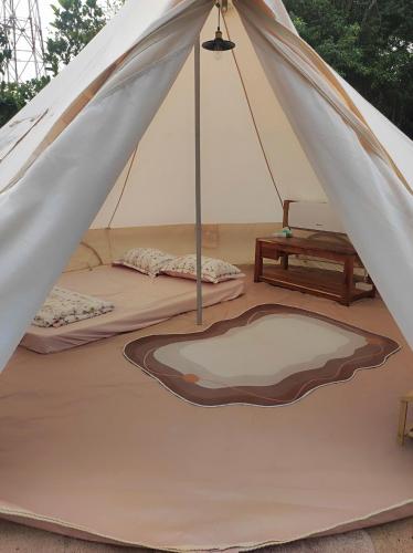 a canvas tent with two beds and a table at Tháng Tư Glamping in Ha Tien