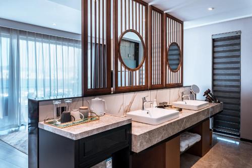 Un baño con dos lavabos y un espejo grande. en Dali Shushanju Seaview Holiday Villa, en Dali
