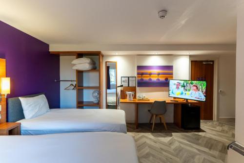 a hotel room with two beds and a desk with a computer at Tyger Inn Derby in Derby
