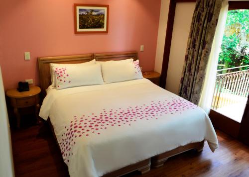 a bedroom with a large white bed with a window at La Casa Del Arbol Hotel Boutique Villa de Leyva in Villa de Leyva
