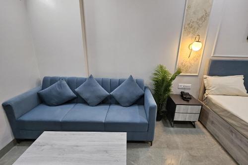 a blue couch in a living room with a bed at Urban Suites by BluSalzz, Jaipur - Rajasthan in Jaipur