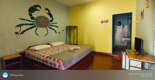 a bedroom with a bed with a spider on the wall at Tanjung Inn in Kuantan