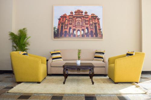 斋浦尔Urban Suites by BluSalzz, Jaipur - Rajasthan的客厅里有两把椅子、一张沙发和一张桌子