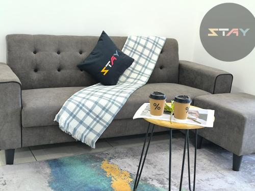 a living room with a couch and two coffee cups on tables at Almas Couple Urban Retreat Puteri Harbour BySTAY in Iskandar Puteri