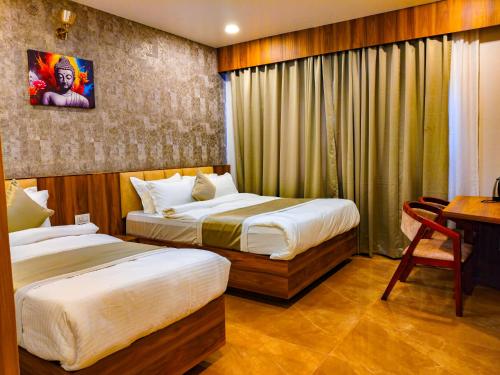 a hotel room with two beds and a desk at Airport Hotel Bhadrapur in Bhadrapur Airport
