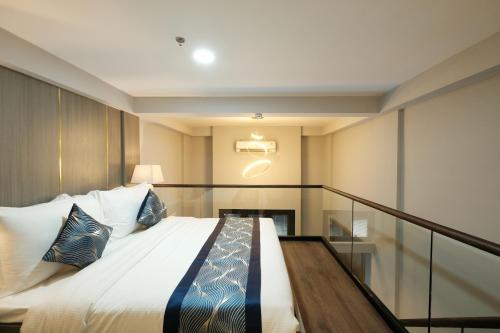 a bedroom with a large bed with pillows on it at Aster Apartment Bali in Canggu
