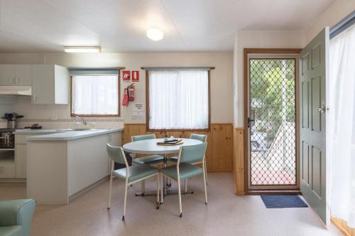 a kitchen with a table and chairs in a room at Daylesford Holiday Park in Daylesford