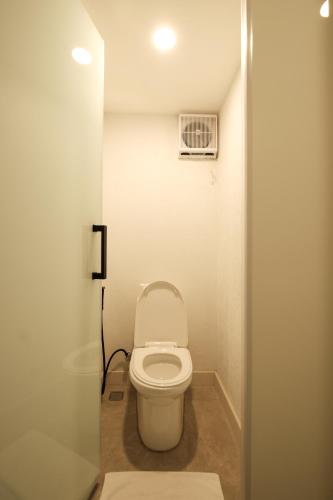 a bathroom with a toilet in a small room at Aster Apartment Bali in Canggu