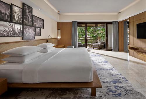 a bedroom with a large white bed and a television at Grand Hyatt Bali in Nusa Dua