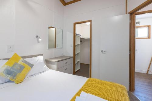 a bedroom with a white bed and a mirror at Daylesford Holiday Park in Daylesford