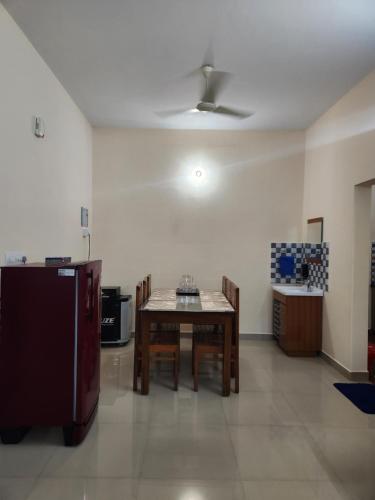 a dining room with a table and a refrigerator at Centerland Harmony in Thodupuzha