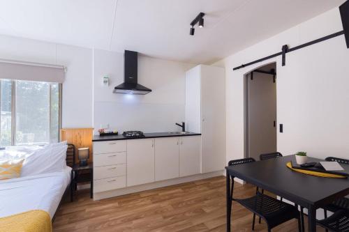a bedroom with a bed and a table and a kitchen at Daylesford Holiday Park in Daylesford