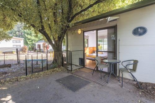 a patio with a table and chairs next to a house at Daylesford Holiday Park in Daylesford