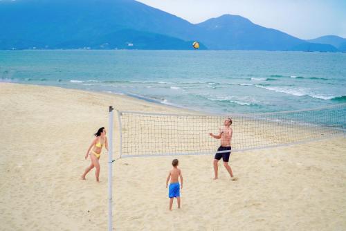 a group of people playing volleyball on the beach at Da Nang - Mikazuki Japanese Resorts & Spa in Da Nang
