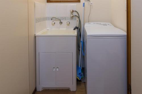 a small bathroom with a sink and a refrigerator at Daylesford Holiday Park in Daylesford