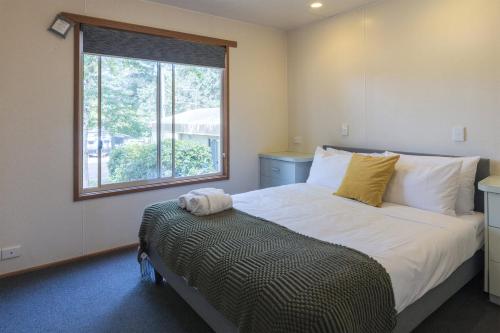 a bedroom with a large bed with a window at Daylesford Holiday Park in Daylesford