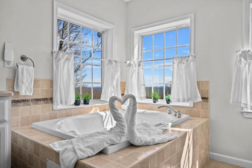 a bathroom with a tub with two swans sitting on it at Spacious 6 BR Villa - Serene Scenic Mountain Escape in Bloomingburg