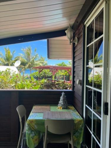 a table on a porch with a view of the ocean at Pension LE PASSAGE in Vaitoare