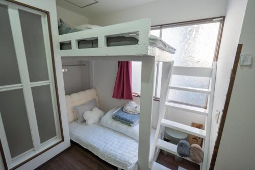 Una pequeña habitación con literas y una ventana. en 王202整套私人卫浴厨房 洗衣机 车站步行5分钟 上野站地铁直达, en Tokio