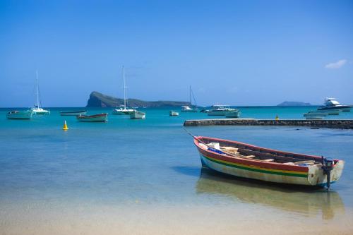 a boat sitting in the water next to a dock at Beach Retreat by C in Bain Boeuf