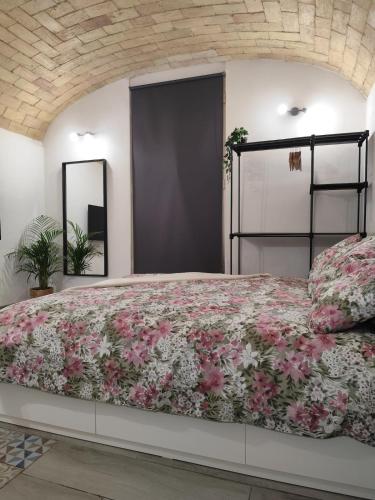 a bedroom with a large bed with pink flowers at Il rifugio delle Azalee in Rome