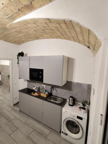 a kitchen with a sink and a washing machine at Il rifugio delle Azalee in Rome
