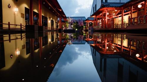 a reflection of buildings in a canal at night at Da Nang - Mikazuki Japanese Resorts & Spa in Da Nang