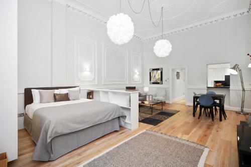 a white bedroom with a bed and a desk at Queensgate Court in London