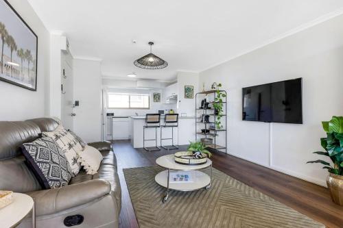 a living room with a couch and a tv at Kalua Holiday Apartments in Maroochydore