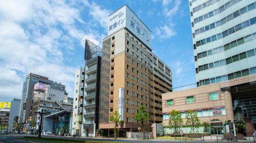 Toyoko Inn Kagoshima Temmonkan No 2 في كاجوشيما: مبنى طويل عليه ساعة