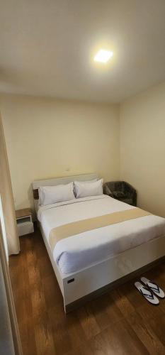 a bedroom with a large bed with white sheets at Bole Central Apartment in Addis Ababa