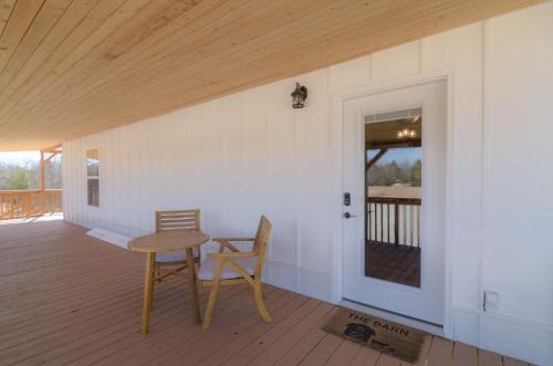 a room with a table and a chair on a deck at The Inn at Beulah Farm - The Barn in Whitley City