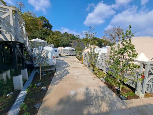 a row of rvs parked next to a white fence at lastpiece in Itoshima