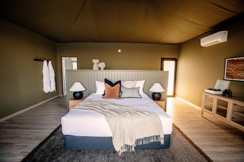 a bedroom with a large bed with pillows at Wilderluxe Lake Keepit in Keepit