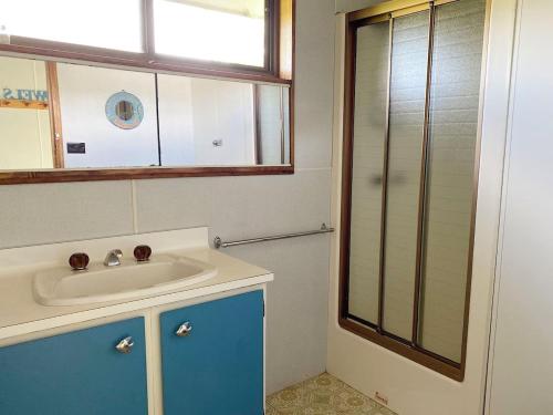 a bathroom with a sink and a glass shower at Oli's at 57 Lakeside Drive, Mallacoota in Mallacoota