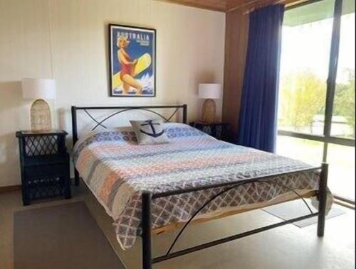 a bedroom with a bed in a room with a window at Oli's at 57 Lakeside Drive, Mallacoota in Mallacoota