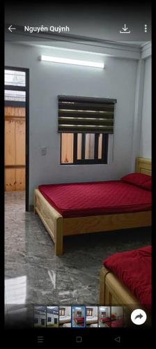 a bedroom with two beds with red sheets and a window at Homestay Dế Xu Phình in Co Ge Phong (1)