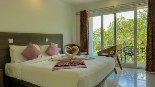 a bedroom with a bed with a bow on it at Forestscape Resort Munnar in Munnar